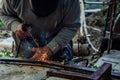Two hands masked welder welding armature outdoors