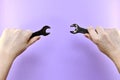 Two hands, one opposite the other, with wrench pointing to the center, at each other Royalty Free Stock Photo