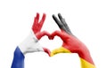 Two hands of a person painted with the flags of Germany and France forming a heart