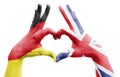 Two hands of a person painted with the flags of Germany and the UK forming a heart