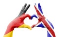 Two hands of a person painted with the flags of Germany and the UK forming a heart