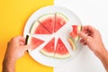 Two hands picking up sliced watermelon off a plate. Point of view of person eating