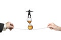 Two hands pulling rope businessman balancing on hourglass Royalty Free Stock Photo