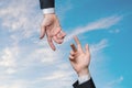 Two hands are reaching each other against blue sky. Help and assistance concept Royalty Free Stock Photo