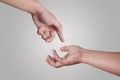 Two hands reaching each other, giving and receiving, over grey Royalty Free Stock Photo