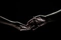 Two hands reaching toward. Helping hand outstretched for salvation on isolated black background. Close up of man and Royalty Free Stock Photo