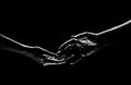 Two hands reaching toward. Helping hand outstretched for salvation on isolated black background. Close up of man and Royalty Free Stock Photo