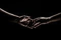 Two hands reaching toward. Helping hand outstretched for salvation on isolated black background. Close up of man and Royalty Free Stock Photo