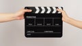 Two hands send and hold Black clapper board or movie slate on white background