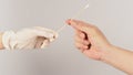 Two hands send and hold cotton swab or cotton stick on white background. One hand wear a white latex glove