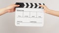 Two hands send and hold white clapper board or movie slate on white background