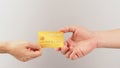 Two hands send and receive gold credit card on white background