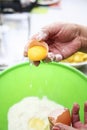 Two hands separating eggwhite from yolk over green Royalty Free Stock Photo