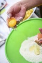 Two hands separating eggwhite from yolk over green Royalty Free Stock Photo