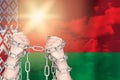 Two hands shackled a metal chain on Belarus flag. Freedom concept