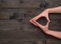 Two hands shape a triangular figure with fingers placed carefully on wooden background. image conveys unity and Royalty Free Stock Photo