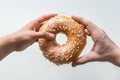 two hands sharing a large donut, break apart gesture