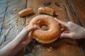 two hands sharing a large donut, break apart gesture