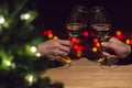 Two hands toasting glasses of Rose wine on wooden table. Royalty Free Stock Photo