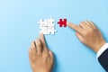 Two hands trying to connect couple puzzle piece on blue background. Teamwork concept. Closeup hand of connecting jigsaw puzzle Royalty Free Stock Photo