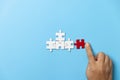 Two hands trying to connect couple puzzle piece on blue background. Teamwork concept. Closeup hand of connecting jigsaw puzzle Royalty Free Stock Photo