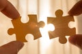 two hands trying to connect couple puzzle piece. with sunset background Royalty Free Stock Photo