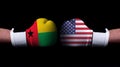 Two hands of wearing boxing gloves with USA and Guinea-Bissau flag. Boxing competition concept. Confrontation between two