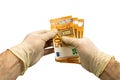 Two hands in white medical protective gloves are counting a pack of notes in denominations of 50 fifty euros. Isolated white backg Royalty Free Stock Photo