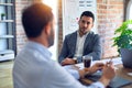 Two handsome businessmen sitting and speaking relaxed at the office Royalty Free Stock Photo