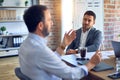 Two handsome businessmen sitting and speaking relaxed at the office Royalty Free Stock Photo