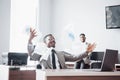 Two handsome cheerful african american businessman celebration successful with throwing paper in workplace Royalty Free Stock Photo