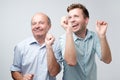 Two handsome friends dancing on birthday party. Son and father are so happy they won in lottery Royalty Free Stock Photo