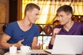 Two handsome men talking at lunch. Royalty Free Stock Photo