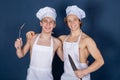 Two handsome chefs with apron on naked muscular body with kitchen utensils on blue background