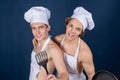 Two handsome chefs with apron on naked muscular body with kitchen utensils on blue background