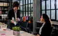 Two handsome smart Caucasian businessman and woman wearing formal suits, using tablet, talking and discussing creative working Royalty Free Stock Photo