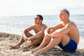 Two handsome young men chatting on a beach Royalty Free Stock Photo