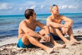 Two handsome young men chatting on a beach Royalty Free Stock Photo