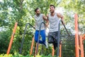 Two handsome young men passionate about fitness doing dips exerc