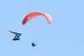 Two hang gliders fly close to each other