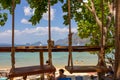 Two hanging swings in outdoor cafe on the beach. Rope swing on tropical seashore. Exotic travel concept. Vacation in paradise.