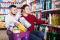 Two happy adult people in good spirits selecting detergents in t Royalty Free Stock Photo