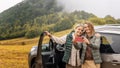 Two happy adult women senior mother and daughter traveling together by car taking selfie standing next to the car Royalty Free Stock Photo