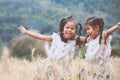 Two asian child girls having fun to play together in the barley field Royalty Free Stock Photo