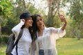 Two college woman using smart phone taking selfie together in campus. Royalty Free Stock Photo