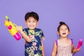Two Happy Asian little boy and girl holding plastic water gun Royalty Free Stock Photo