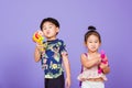 Two Happy Asian little boy and girl holding plastic water gun Royalty Free Stock Photo