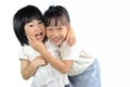 Two happy asian little sisters hugging isolated