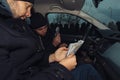 Two happy bank robbers celebrating their successful hit while sitting in the car they used for the robbery