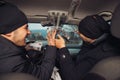 Two happy bank robbers celebrating their successful hit while sitting in the car they used for the robbery Royalty Free Stock Photo